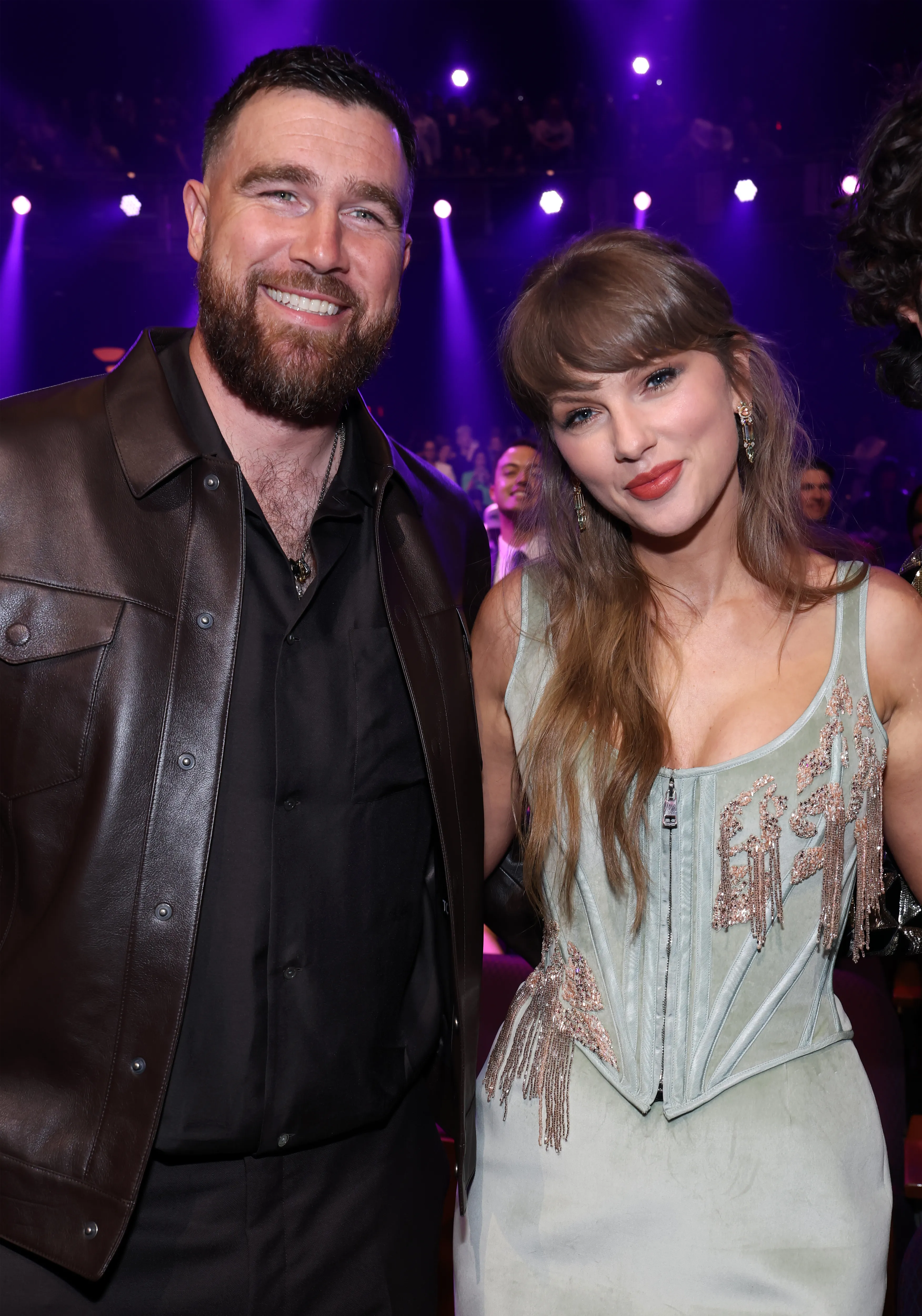 Travis Kelce and Taylor Swift smiling at the iHeartRadio Music Awards.