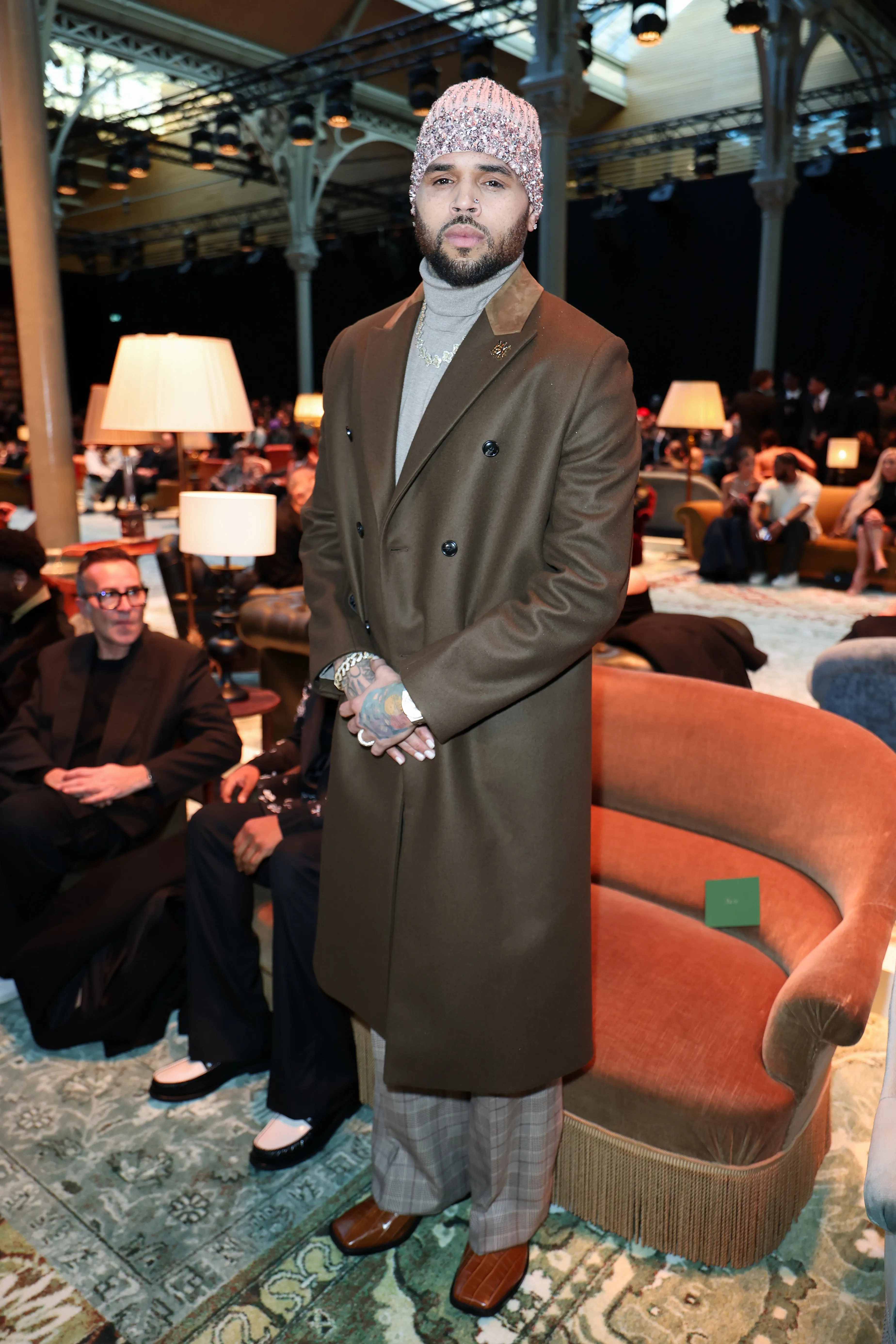 Chris Brown in a brown coat and sparkling beanie at Paris Fashion Week.