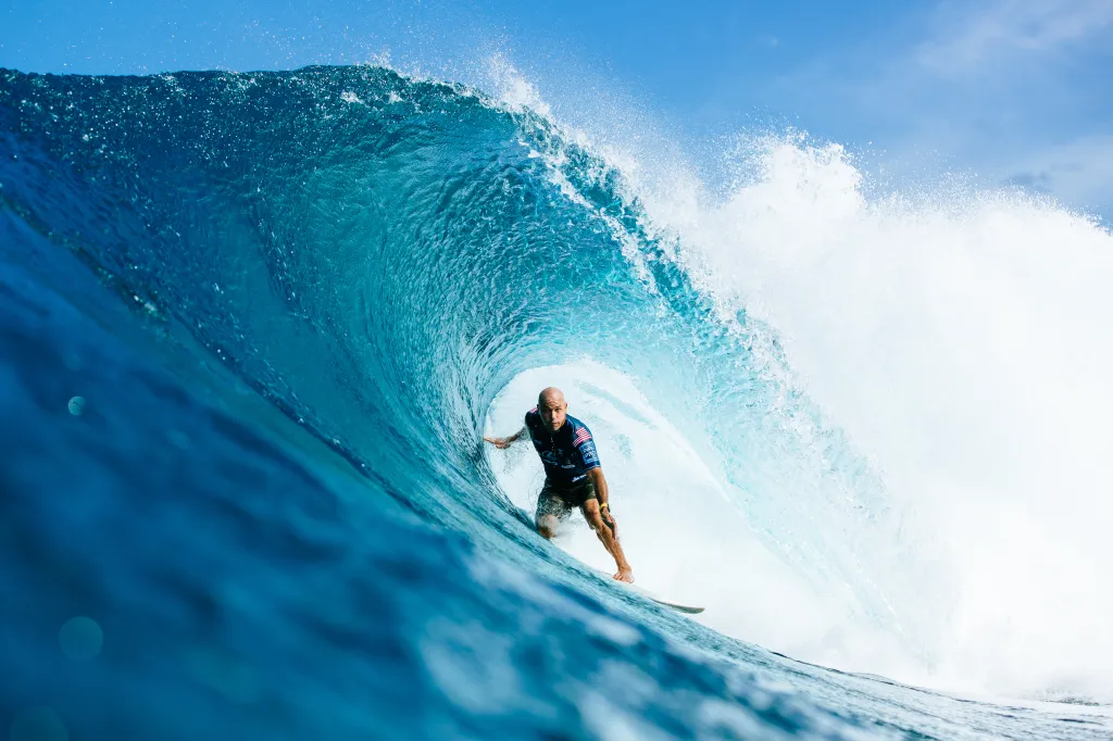 Kelly Slater surfing inside a blue wave barrel at the Lexus Pipe Pro in Oahu, Hawaii.