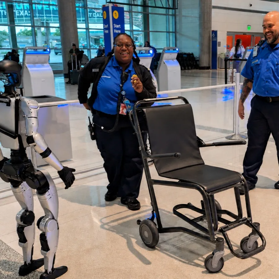 A humanoid robot interacting with airport staff and an empty wheelchair.
