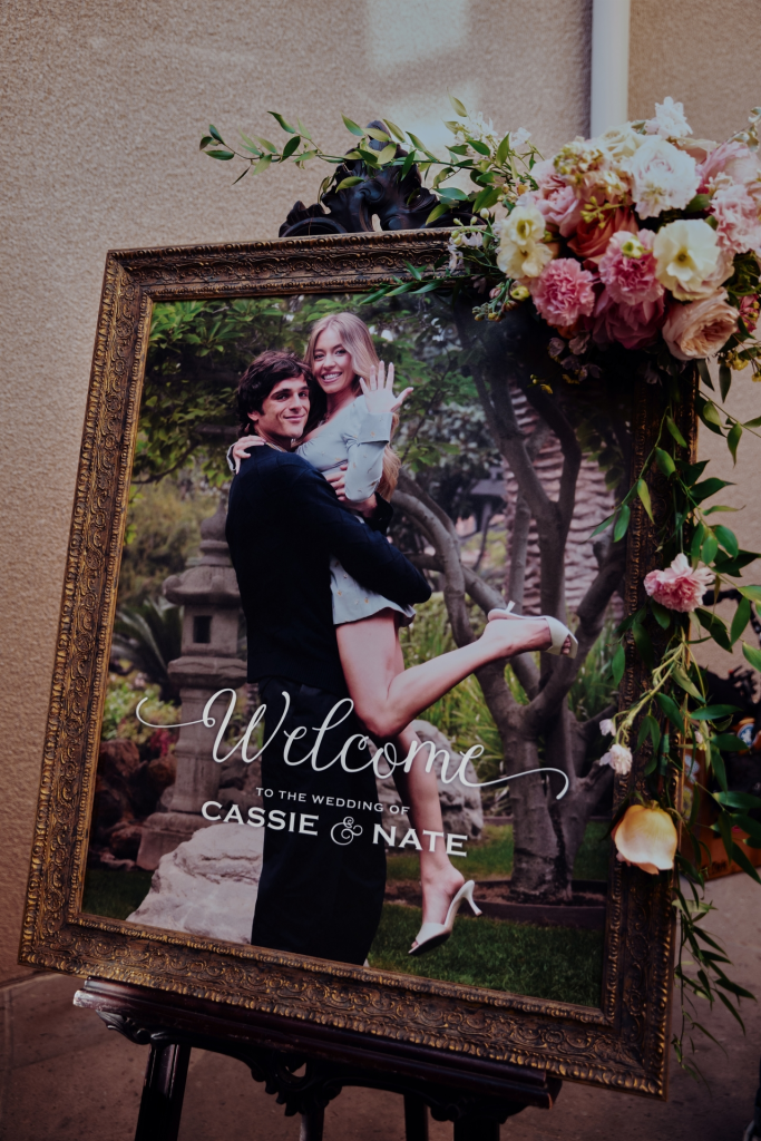 Wedding welcome sign with photo of Jacob Elordi holding Sydney Sweeney, inscribed 