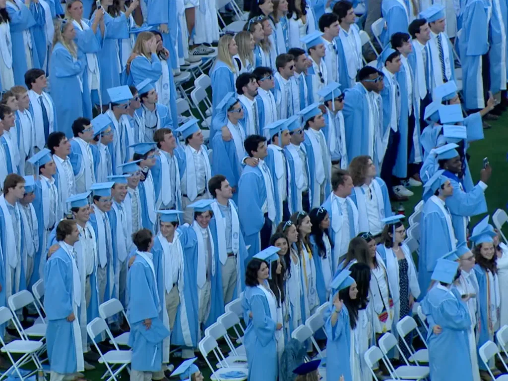 UNC graduates stand and listen to Eric Church singing after he gave his powerful speech at the commencement ceremony.