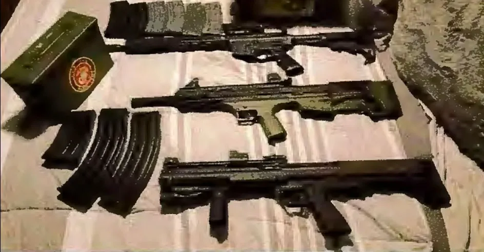 A photo of several firearms, ammunition magazines, and an ammo box.