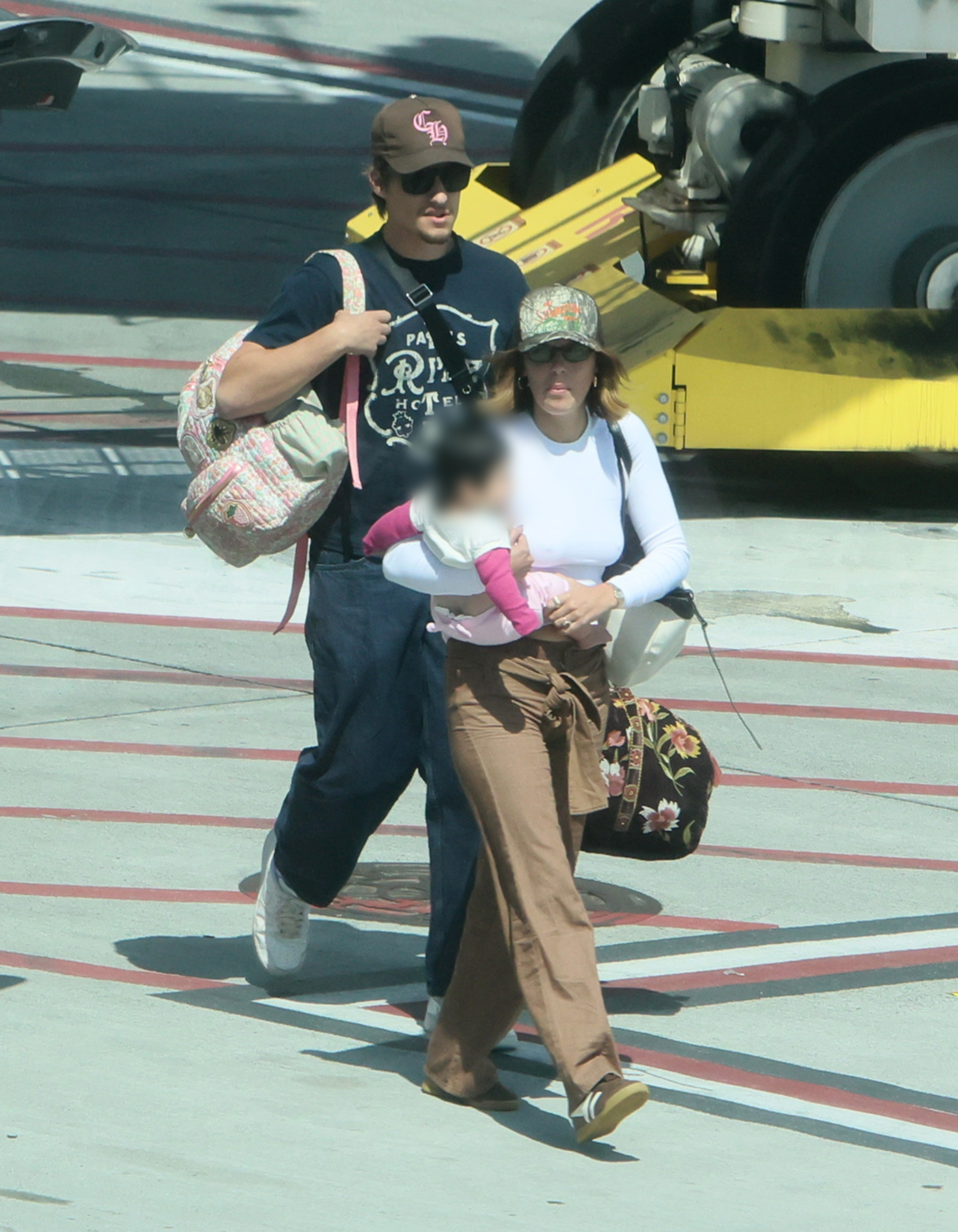 Millie Bobby Brown and Jake Bongiovi arriving at LAX with their daughter.