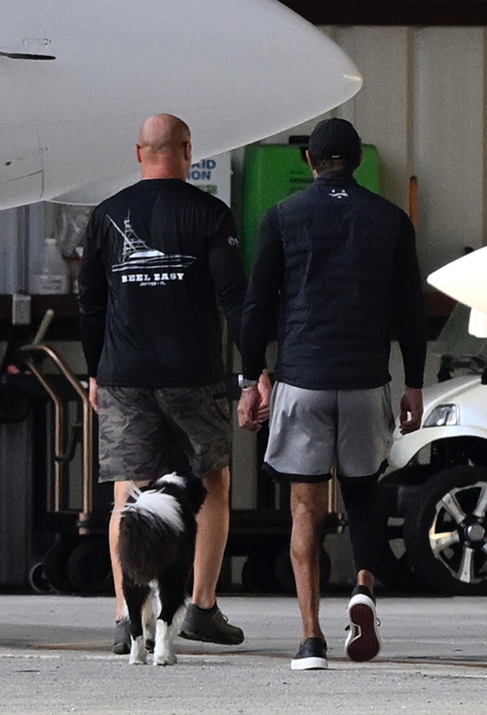 Tiger Woods returning home with a dog and another person after rehab.