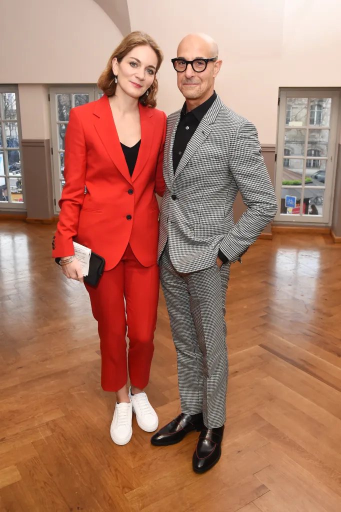 Felicity Blunt in a red Paul Smith suit and Stanley Tucci in a Paul Smith houndstooth suit.