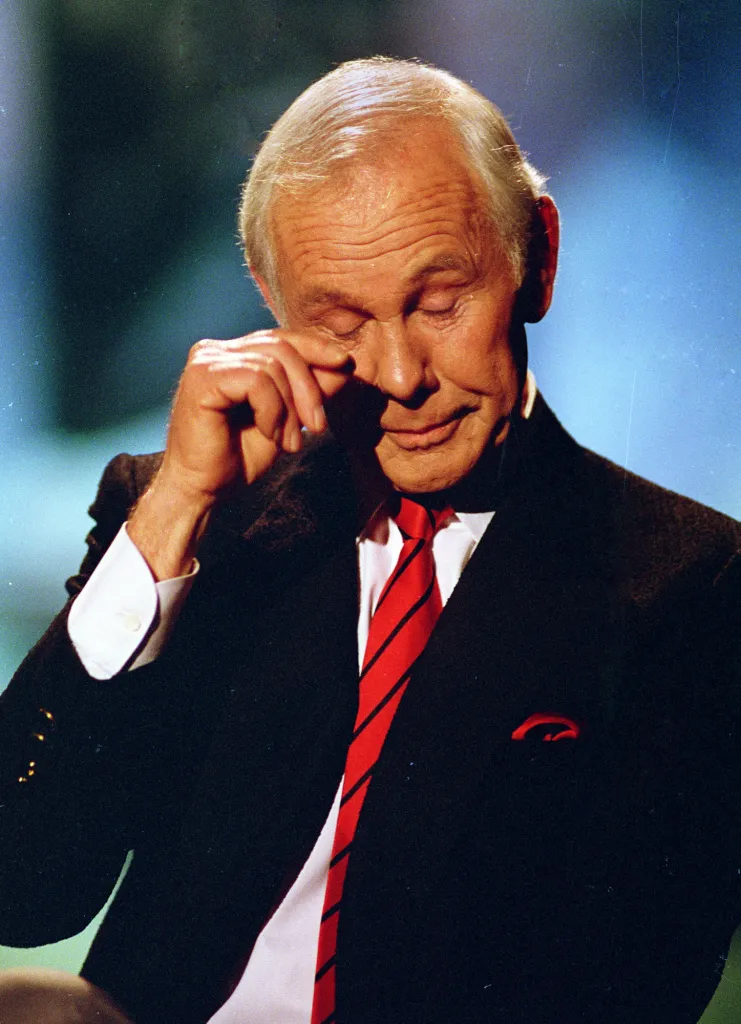 Talk show host Johnny Carson wipes his eye after watching a series of clips from earlier shows during the last taping of