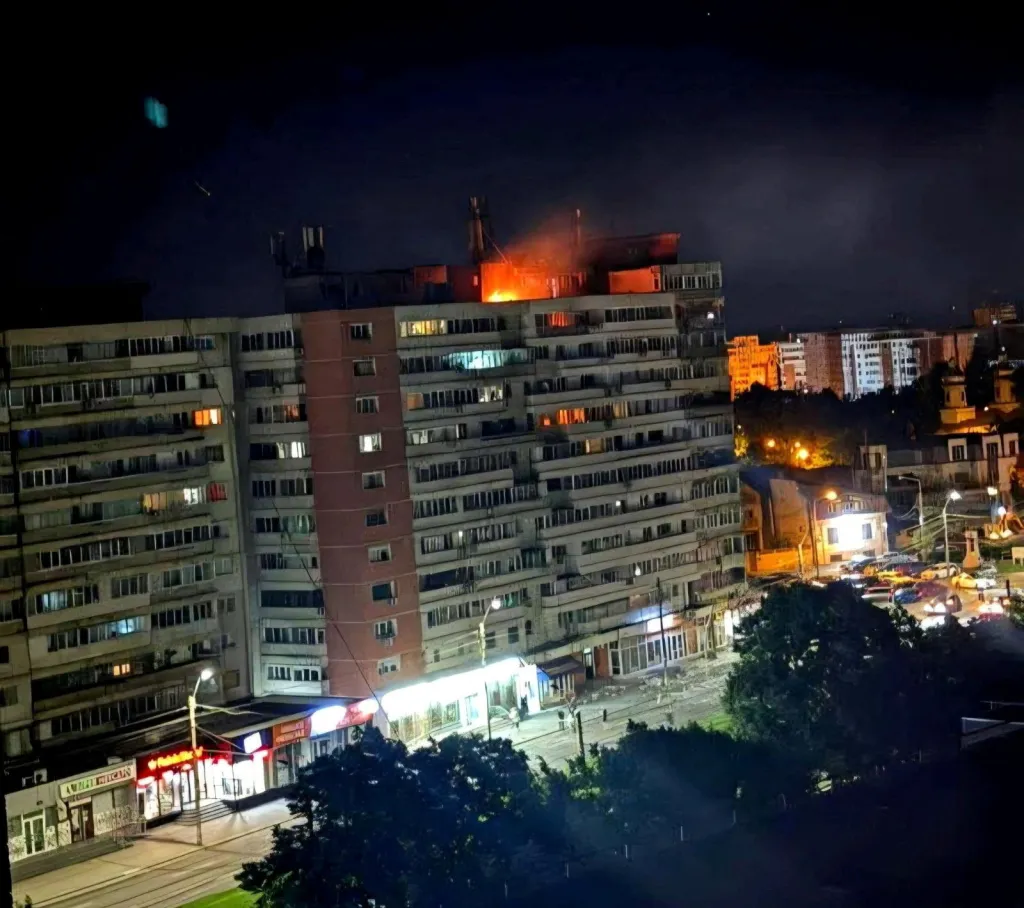 Fire burning on the roof of a 10-story apartment building at night in Galati, Romania.