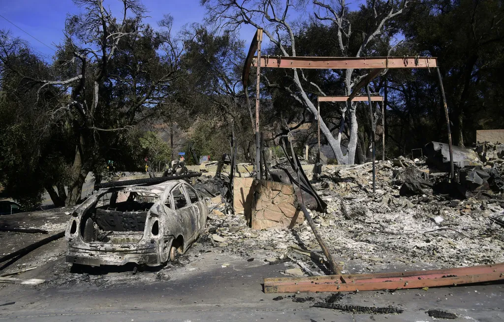 Fire-damaged vehicles and destroyed property on Sierra Creek Road in Agoura Hills, California.