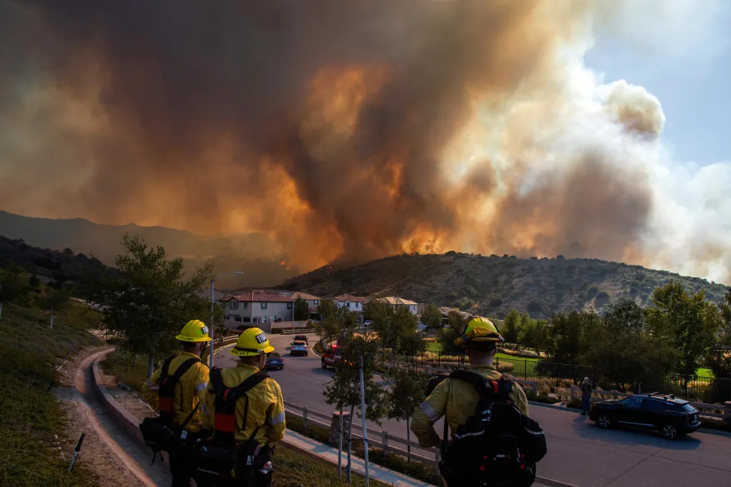 Firefighters watch a massive wildfire approach a residential area in Simi Valley, California.