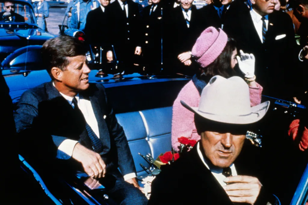 President John F. Kennedy, First Lady Jacqueline Kennedy in pink, and Governor John Connally in a motorcade in Dallas.