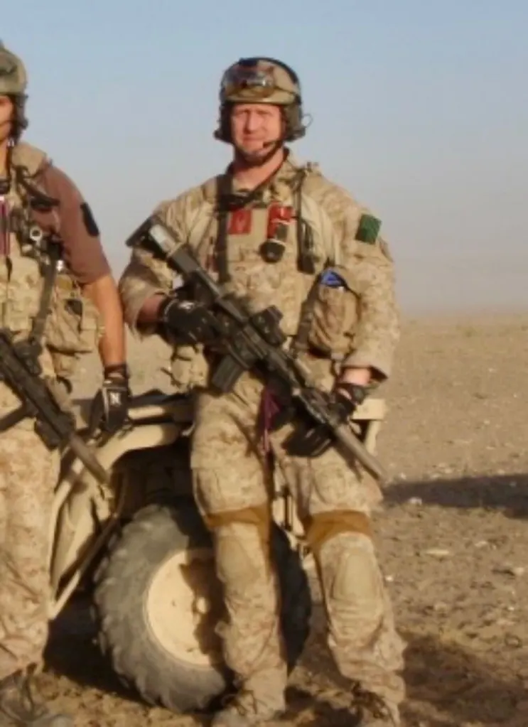 Former U.S. Navy Seal Senior Chief Rob O'Neill in desert camouflage holding the rifle he used to kill Osama Bin Laden.