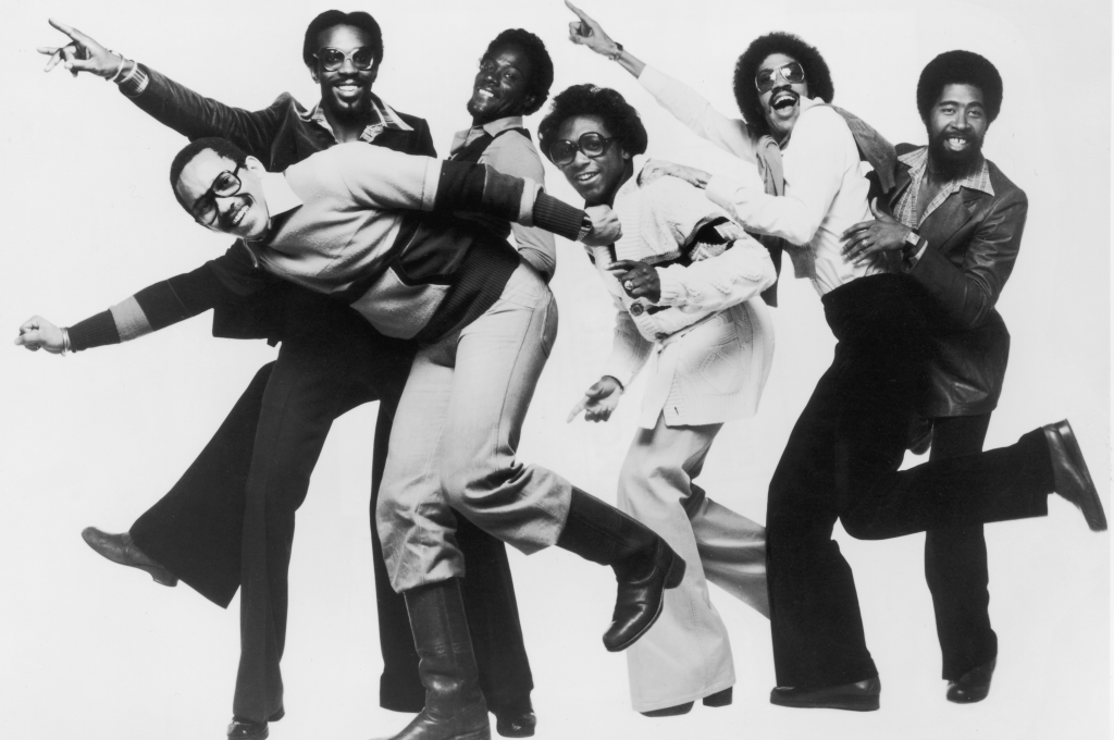Black and white studio portrait of the American R&B and funk group the Commodores posing as if moving forward.