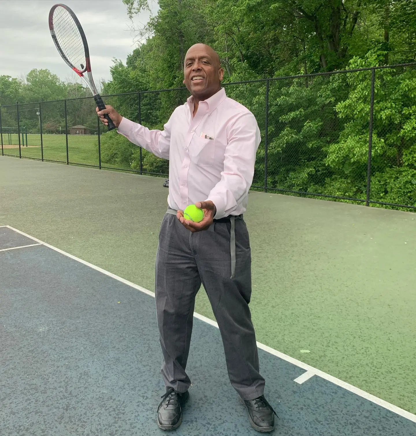 Gayle King's ex-husband, William Bumpus, holding a tennis racket and ball on a tennis court.