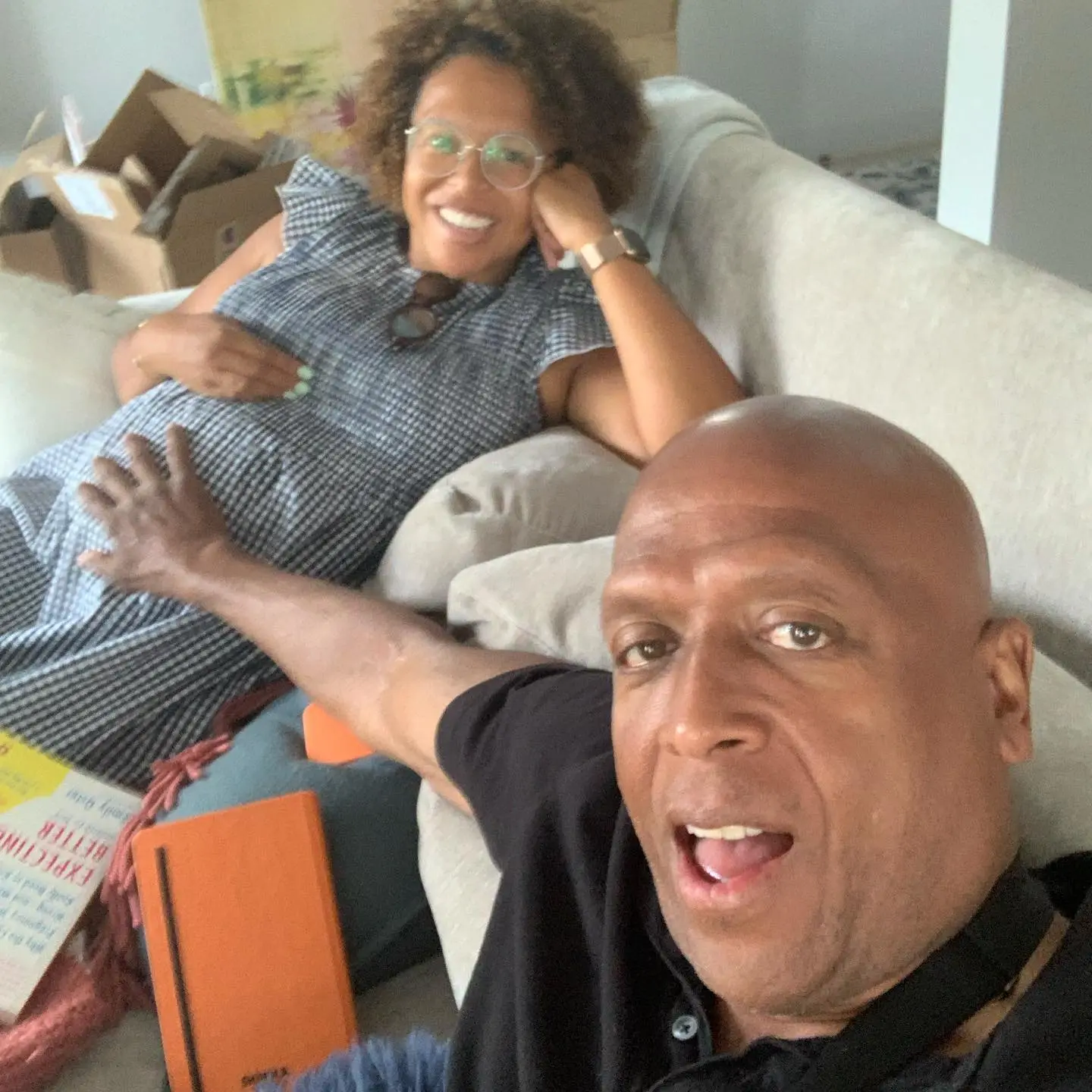 A man taking a selfie with a woman on a couch.