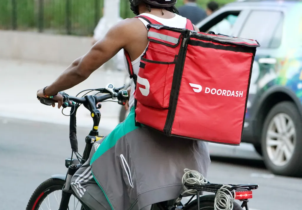A DoorDash food deliveryman on an electric bike.