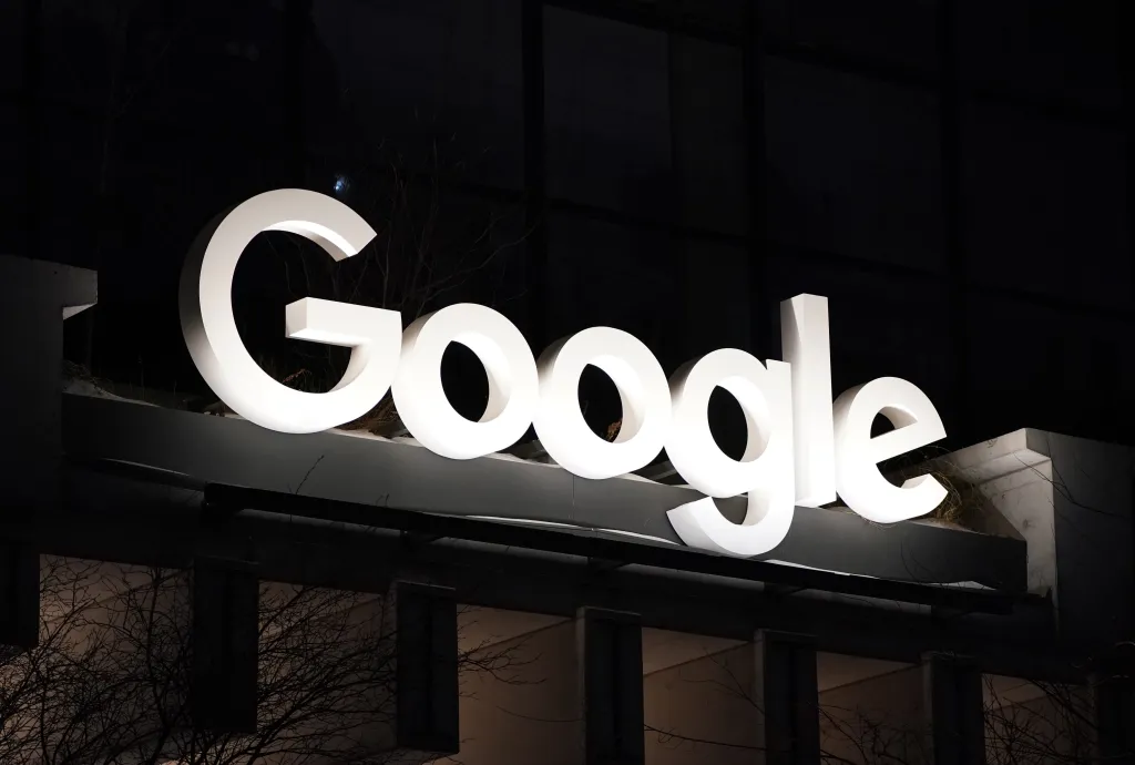 Google logo on the exterior of a building at night.