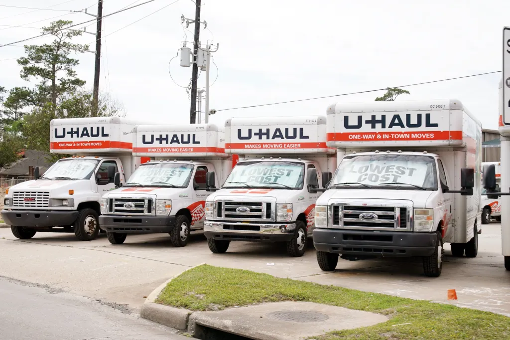 A line of white U-Haul trucks with 