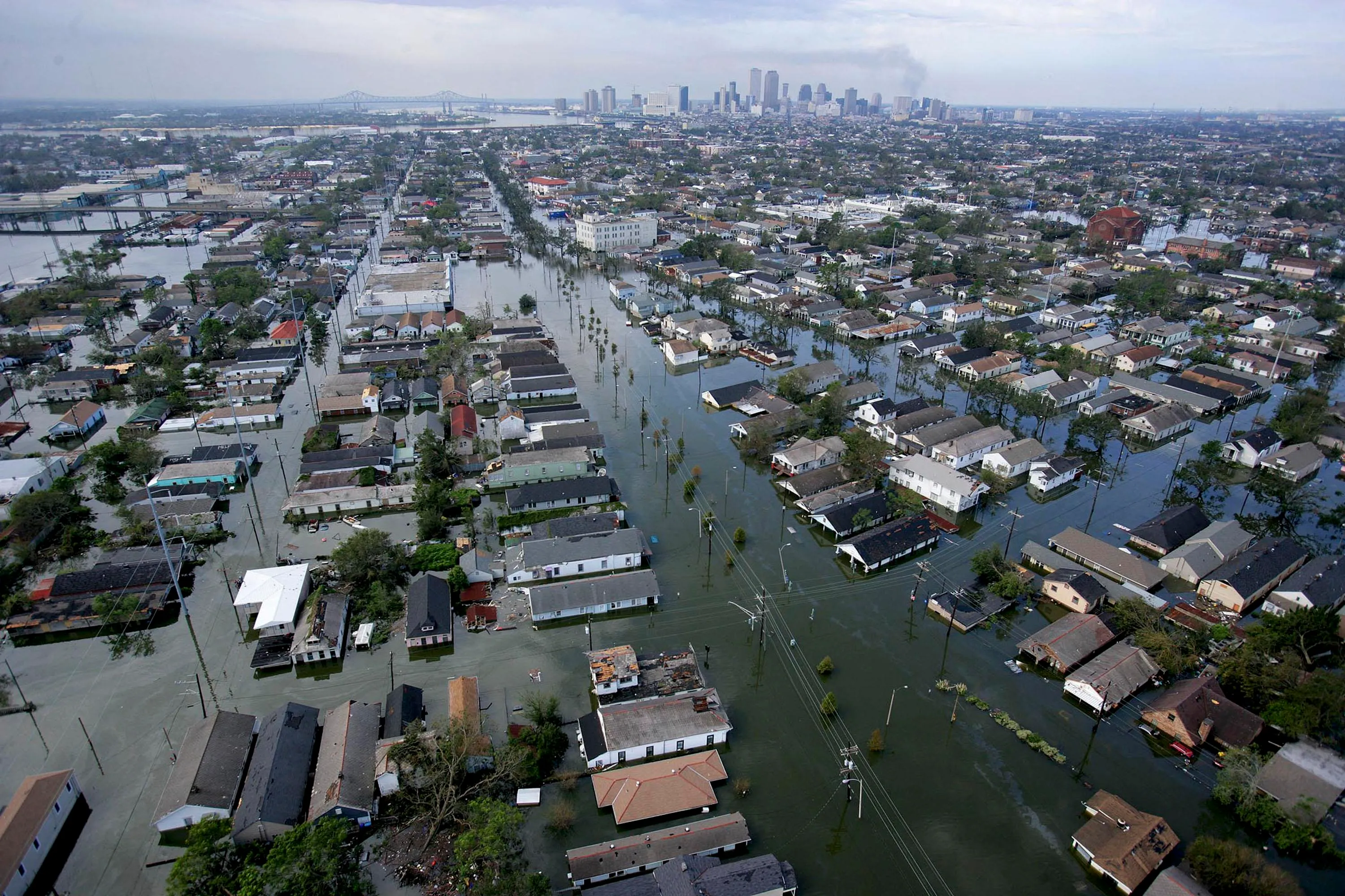 An aerial view of a flooded neighborhood with downtown skyscrapers in the background.