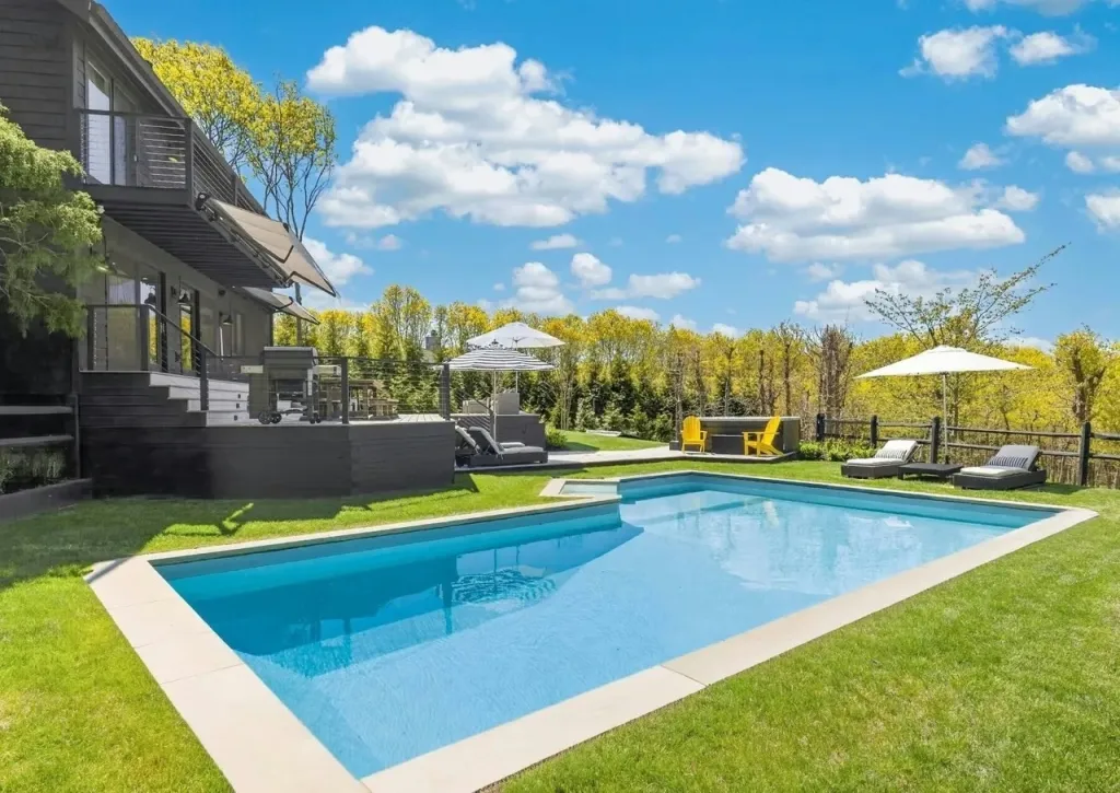 A modern home with a swimming pool and deck in the Hamptons.