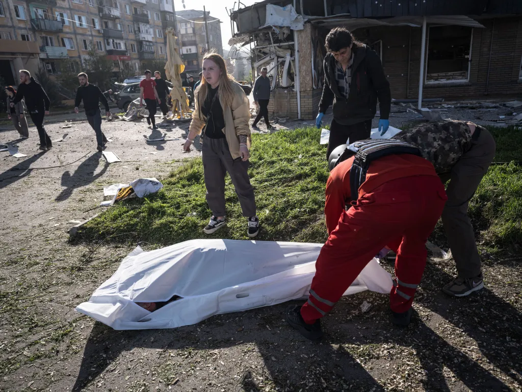 People covering a body in the aftermath of a Russian airstrike in Kramatorsk, Ukraine.