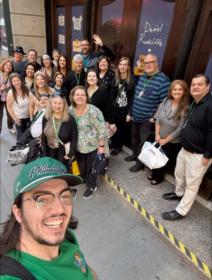 A group of people standing outside a Broadway theater.