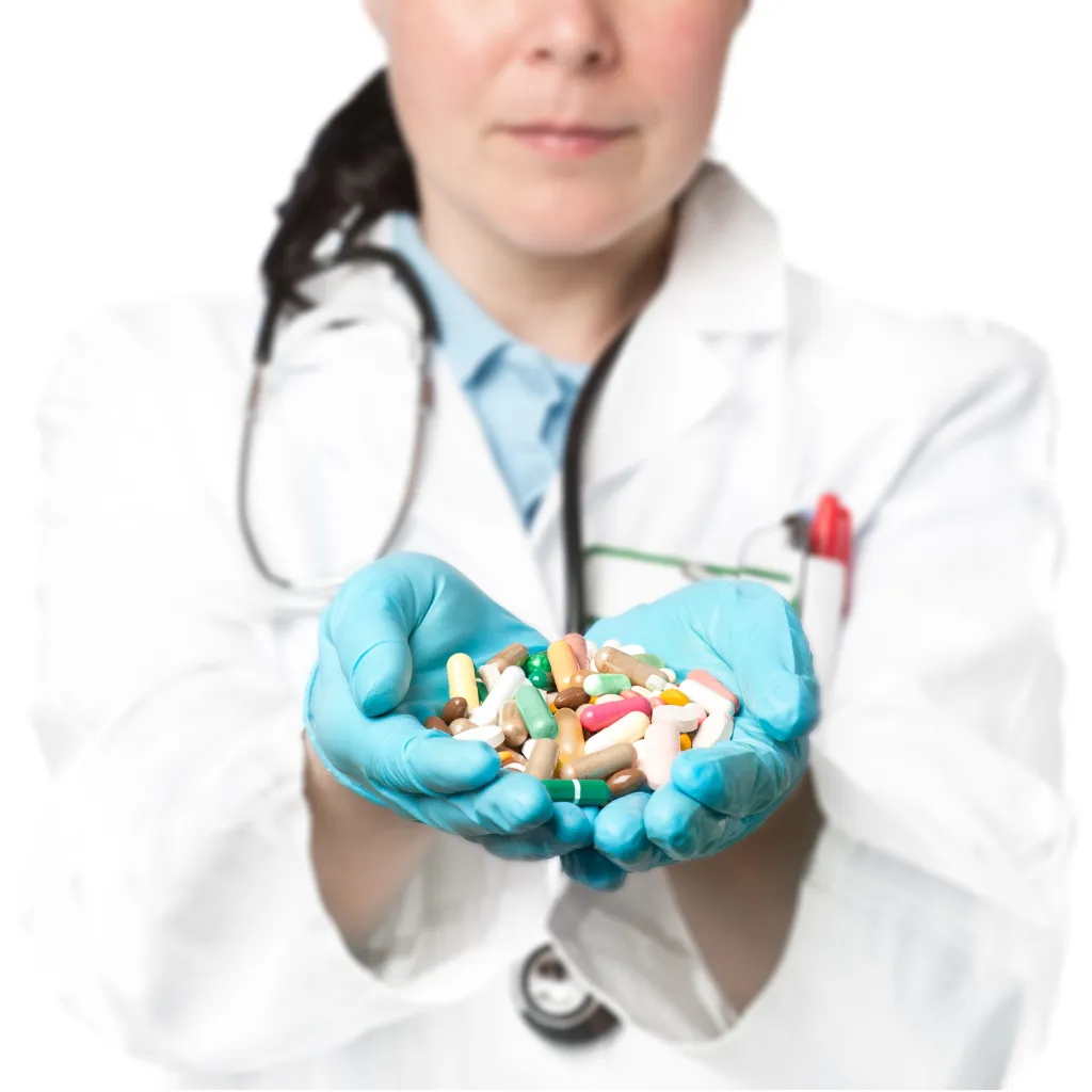 A doctor in blue gloves and a white coat holds a handful of colorful pills.