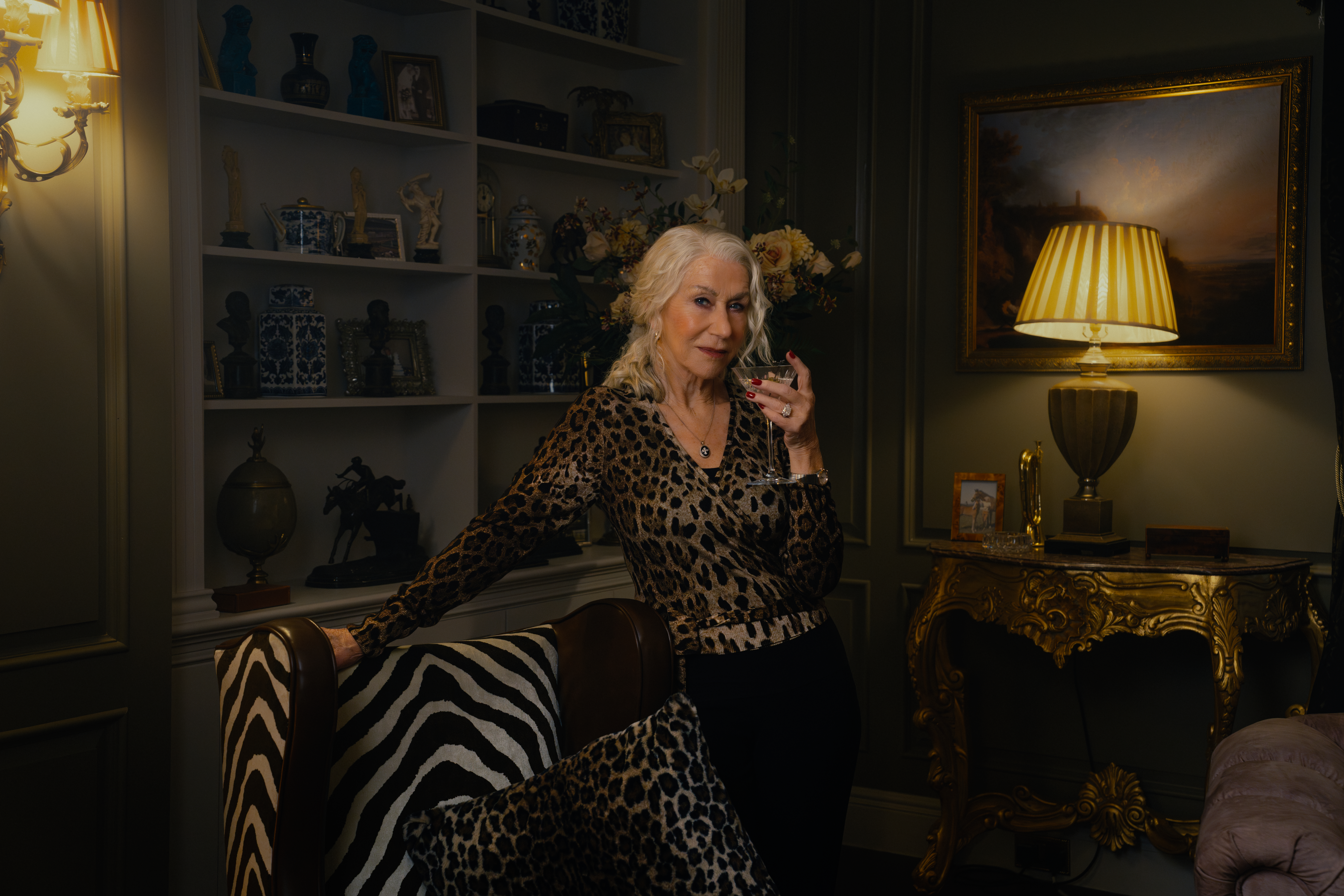Helen Mirren as Maeve Harrigan in Mobland, wearing an animal print top and holding a martini glass.