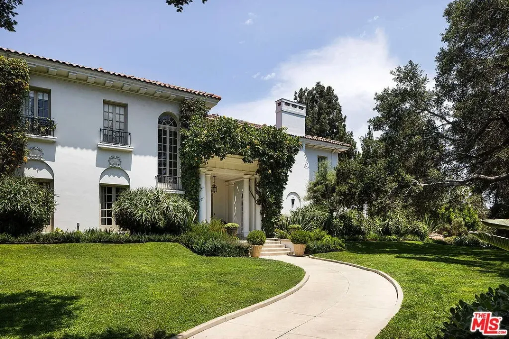 The front exterior of Angelina Jolie's Los Angeles estate, featuring a winding driveway and lush greenery.