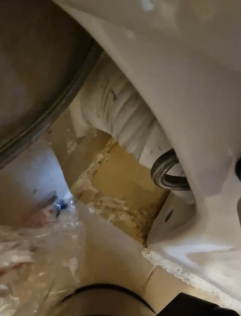 Dirty toilet in a hotel room with feces and urine around the base.