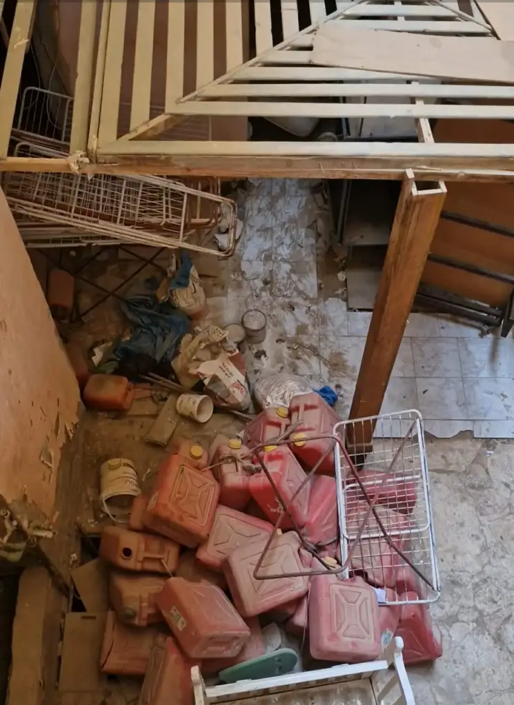 A hotel facility area covered in construction debris and red jerrycans.