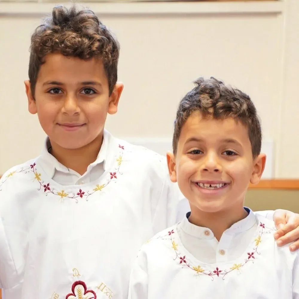 Mark and Jacob Iskander, two boys in white shirts with embroidered collars.