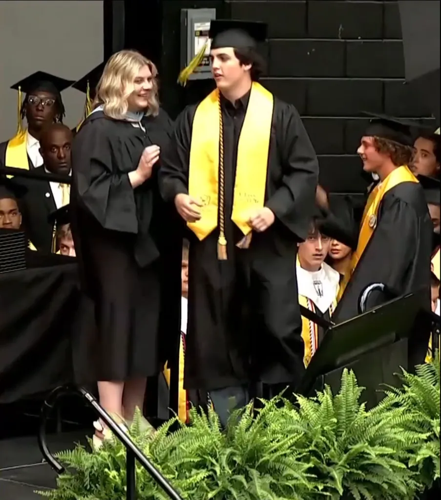 Hunter Metcalf stands on stage to accept the posthumous diploma of his brother, Austin, during Memorial High School's graduation on May 21, 2026.