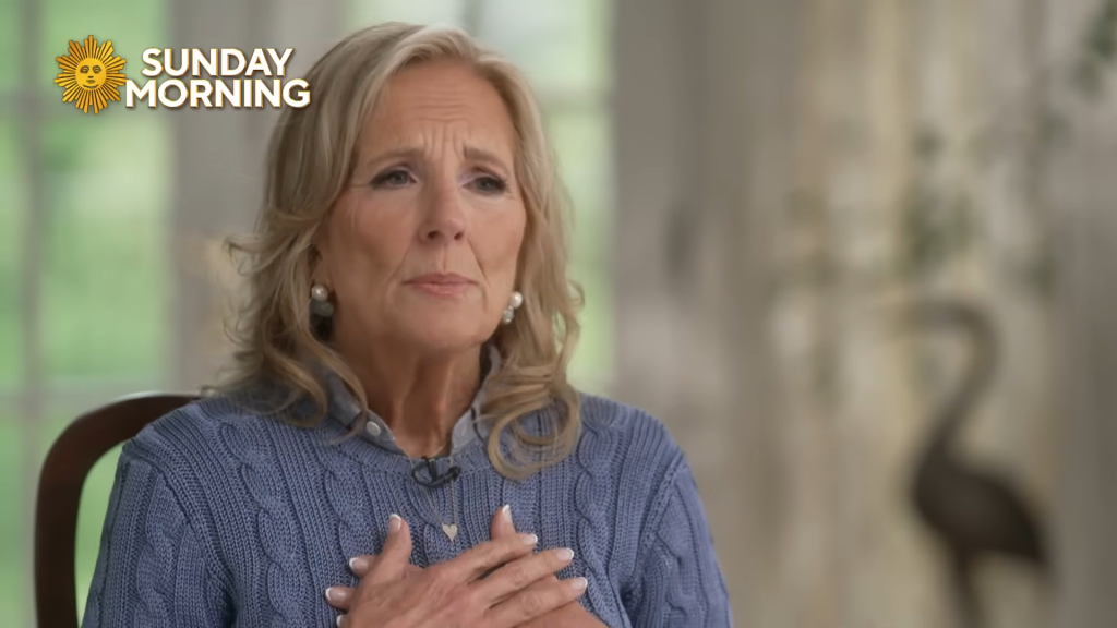 Jill Biden expresses her fear during an interview, wearing a blue knitted sweater with her hand over her chest.