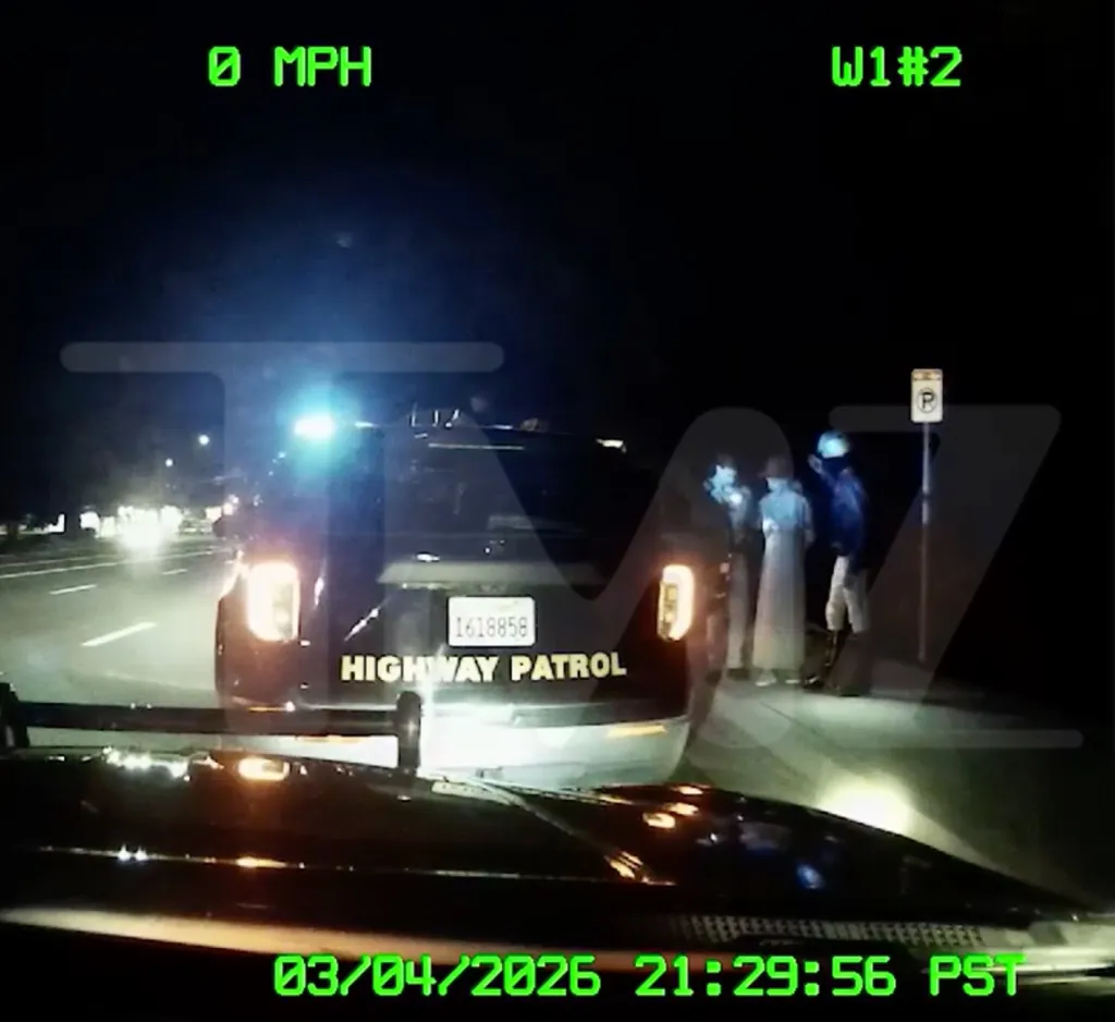 Dashcam footage shows a Highway Patrol car with its lights on, pulled over at night with people standing on the sidewalk.