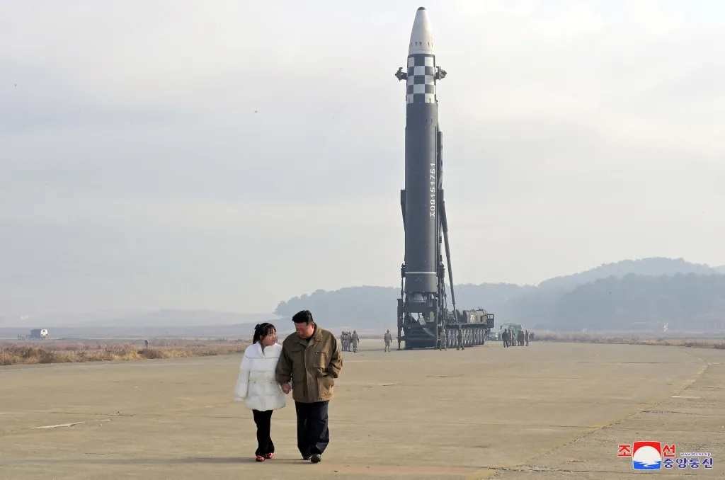 Kim Jong Un and his daughter walk away from an intercontinental ballistic missile.