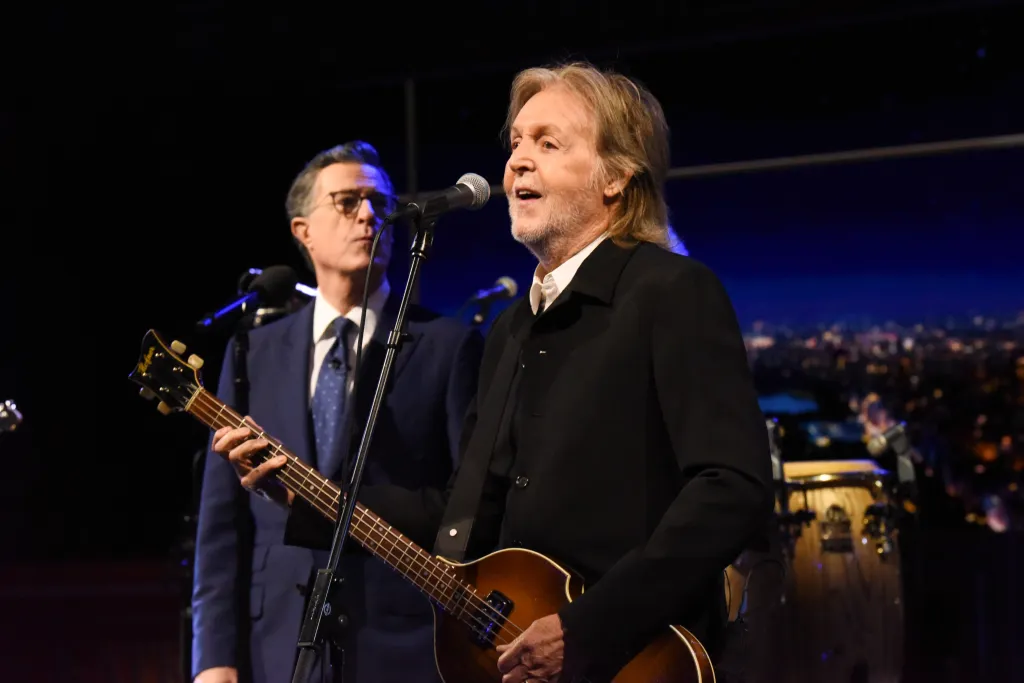 Paul McCartney singing and playing bass next to Stephen Colbert.