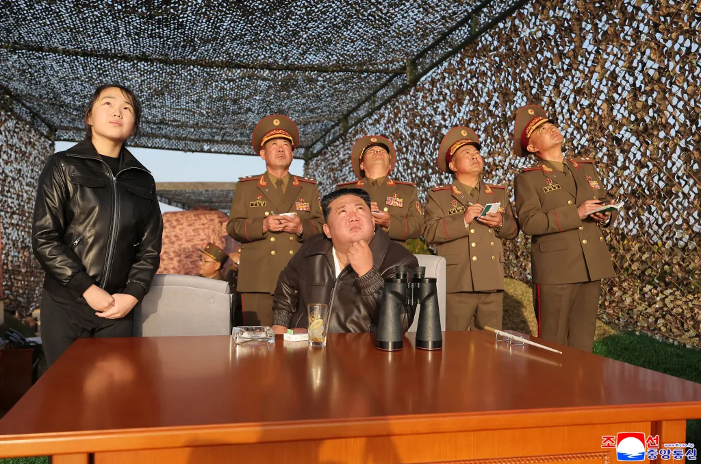 North Korean leader Kim Jong Un and his daughter Kim Ju Ae, along with military officials, watch a ballistic missile test-fire.