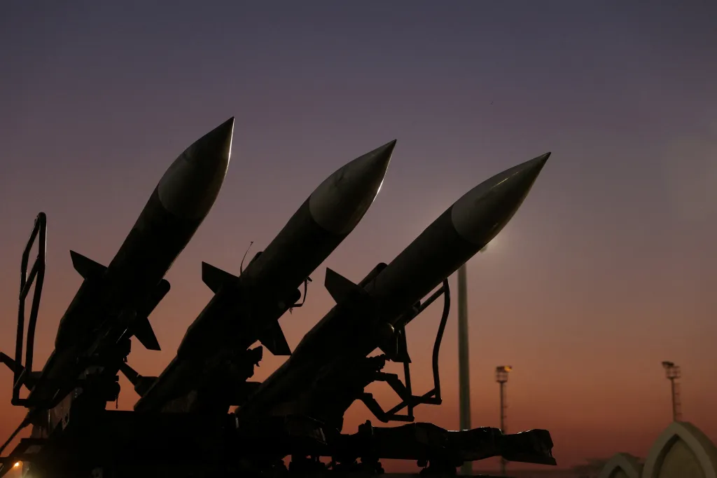Silhouetted missiles against a gradient sky at sunset.