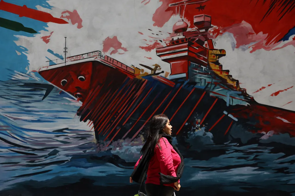 An Iranian woman walks past a mural on the street of Tehran, Iran, on May 6, 2026.
