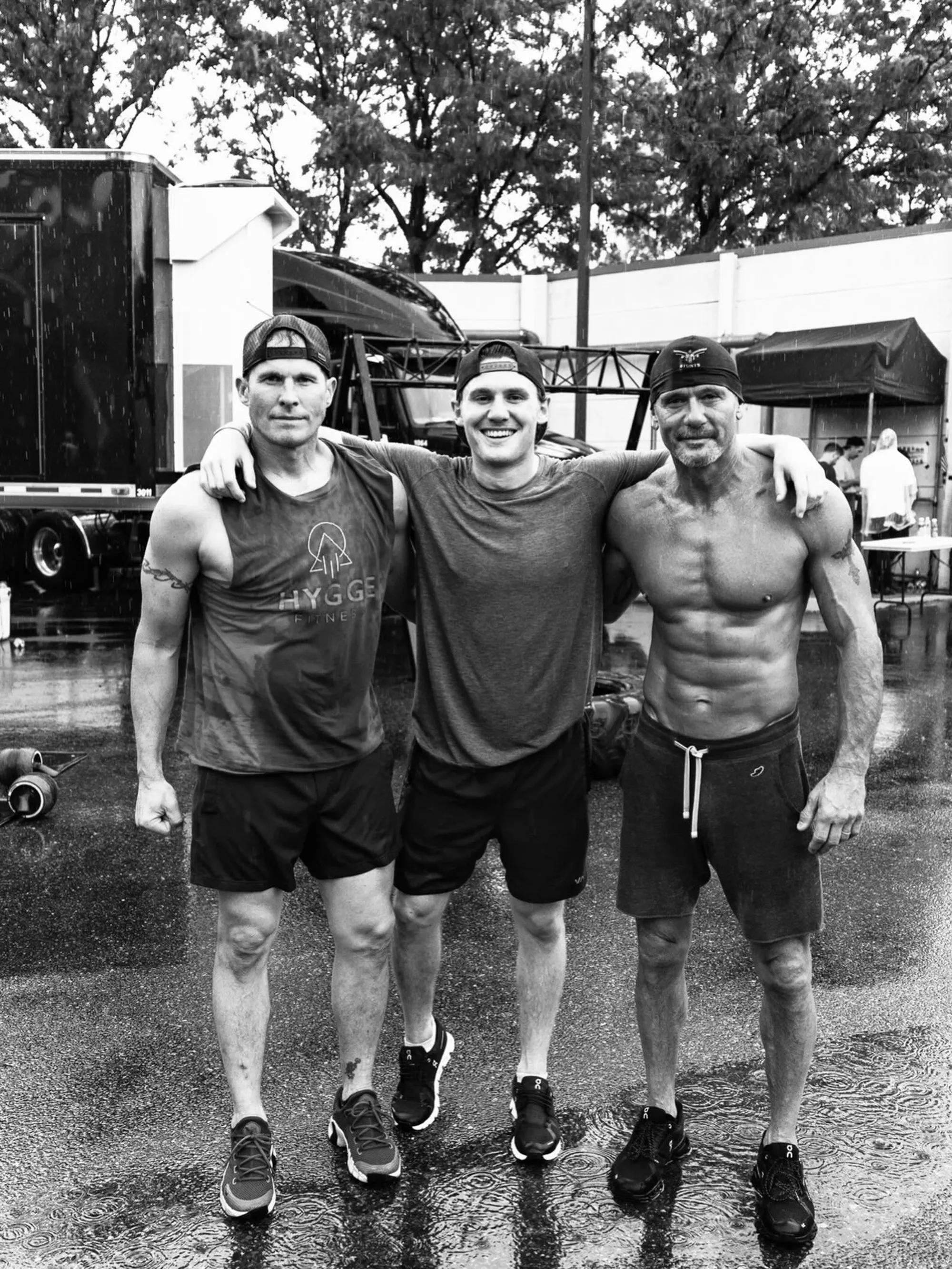 Tim McGraw and his two brothers, Mark and Matthew, posing in the rain.