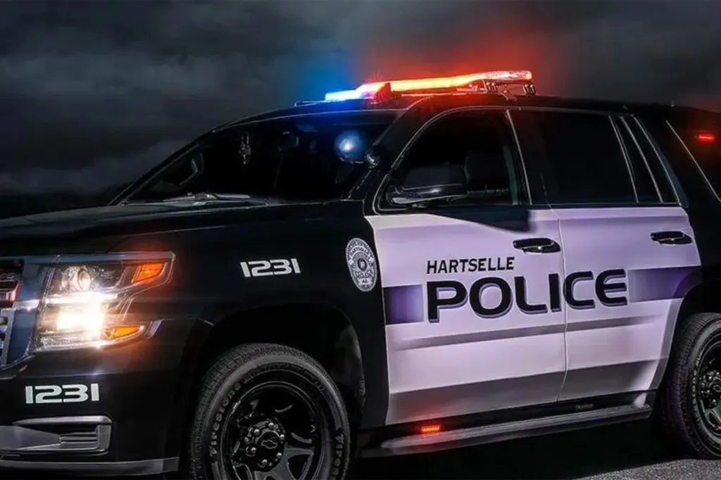 A black and white Hartselle Police vehicle with flashing red and blue lights.
