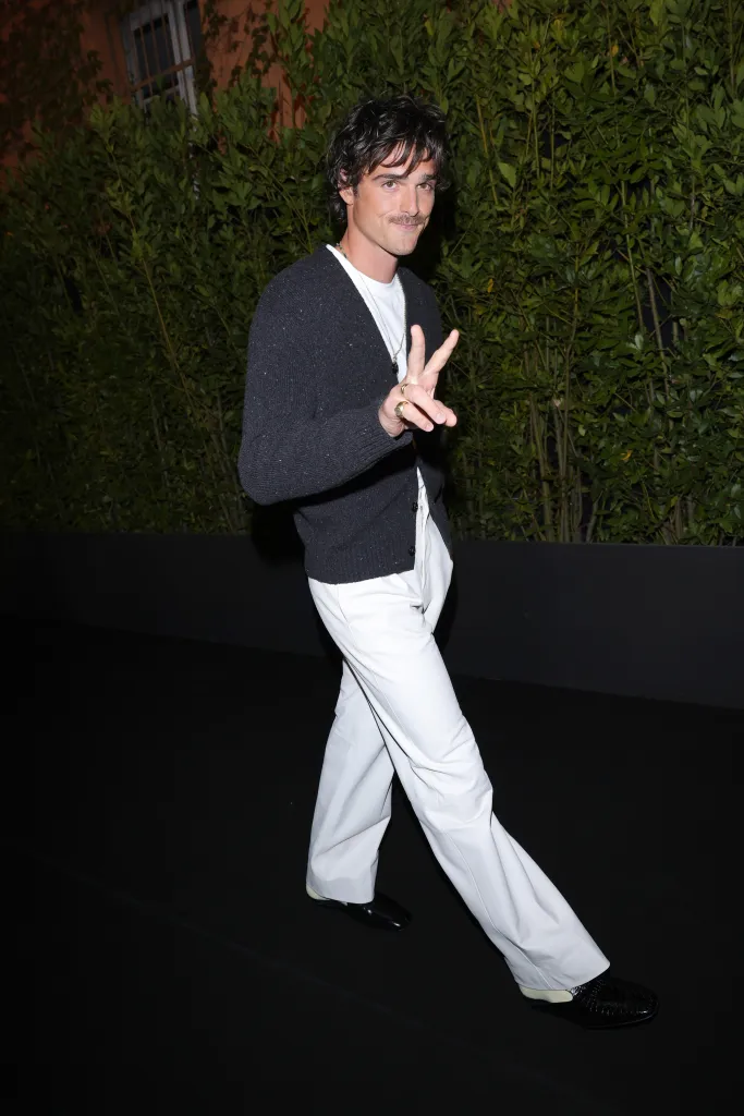 Jacob Elordi making a peace sign at the Bottega Veneta Summer 25 fashion show.