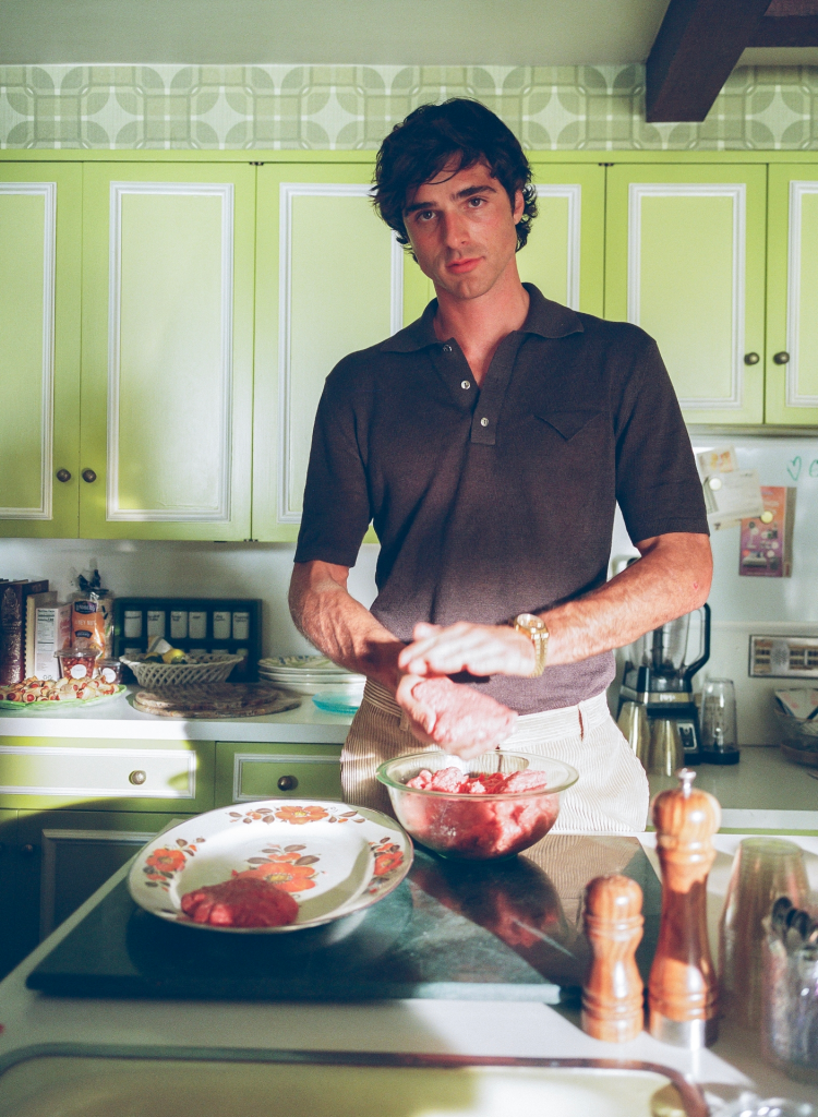 Jacob Elordi preparing raw ground meat in a kitchen.