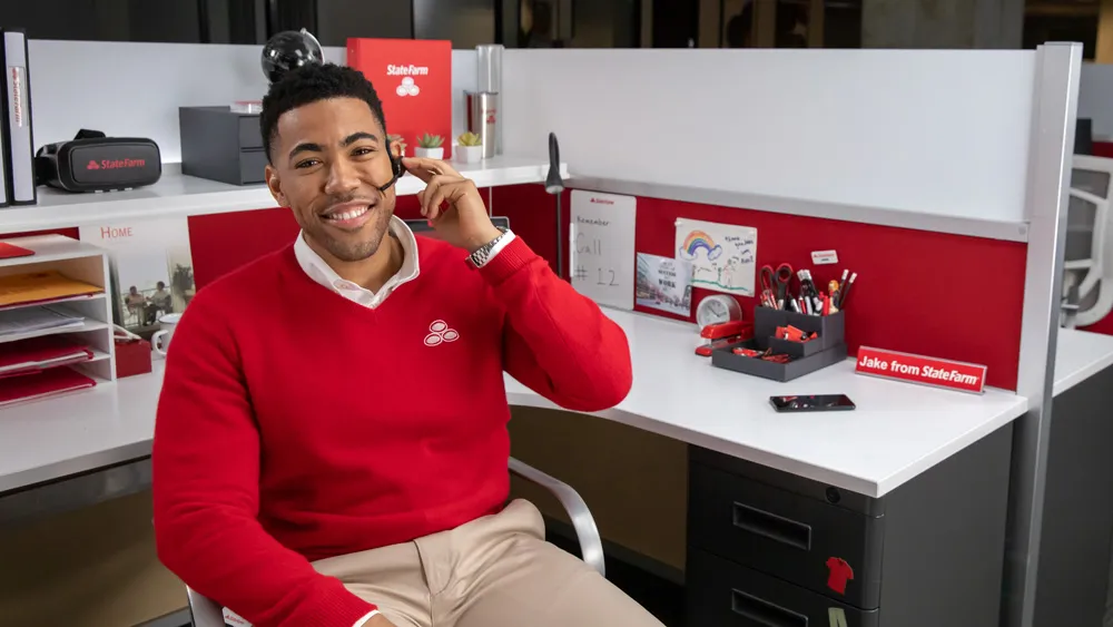 Jake from State Farm sitting at his desk.