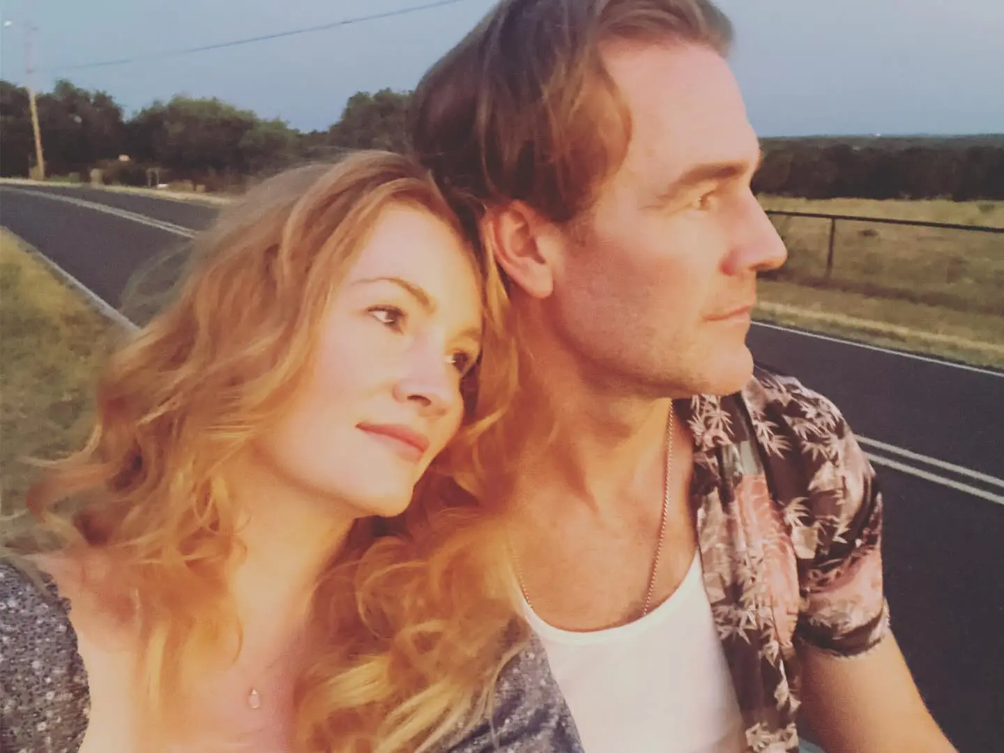 James Van Der Beek and his wife, Kimberly Brook, posing together outdoors.
