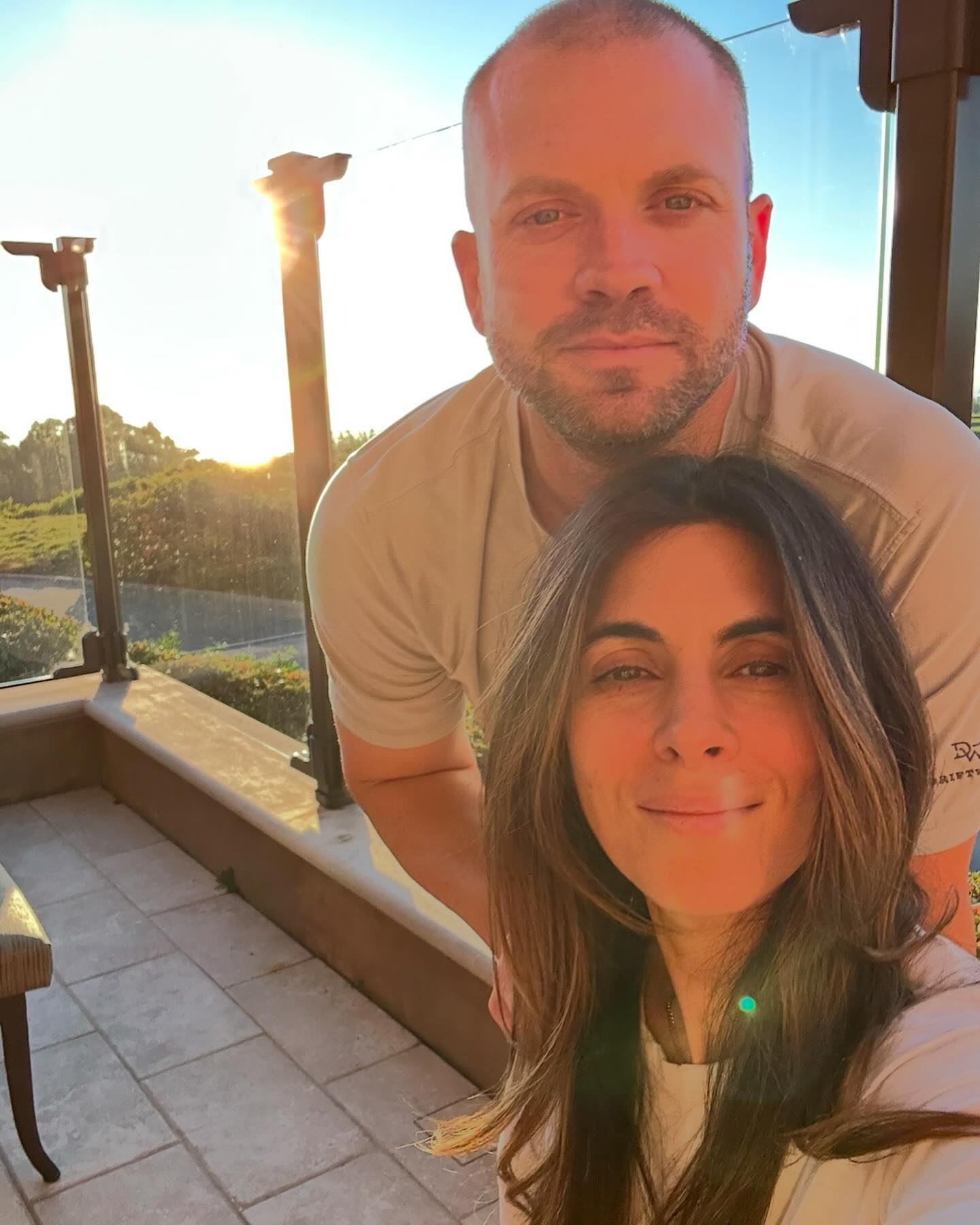 Jamie-Lynn Sigler and her husband pose for a selfie on a balcony during sunset.
