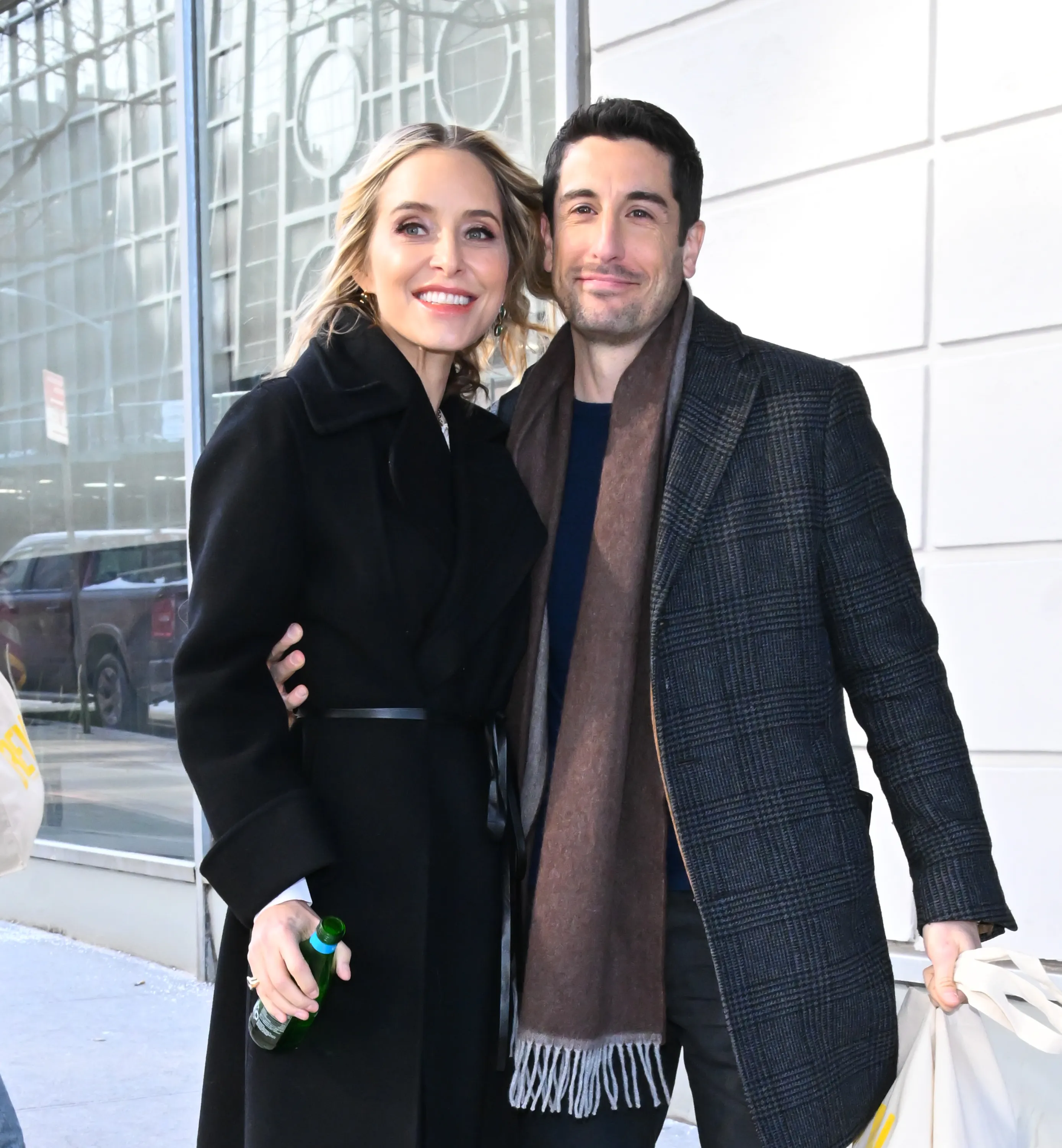 Jenny Mollen and Jason Biggs pose outdoors in winter coats.