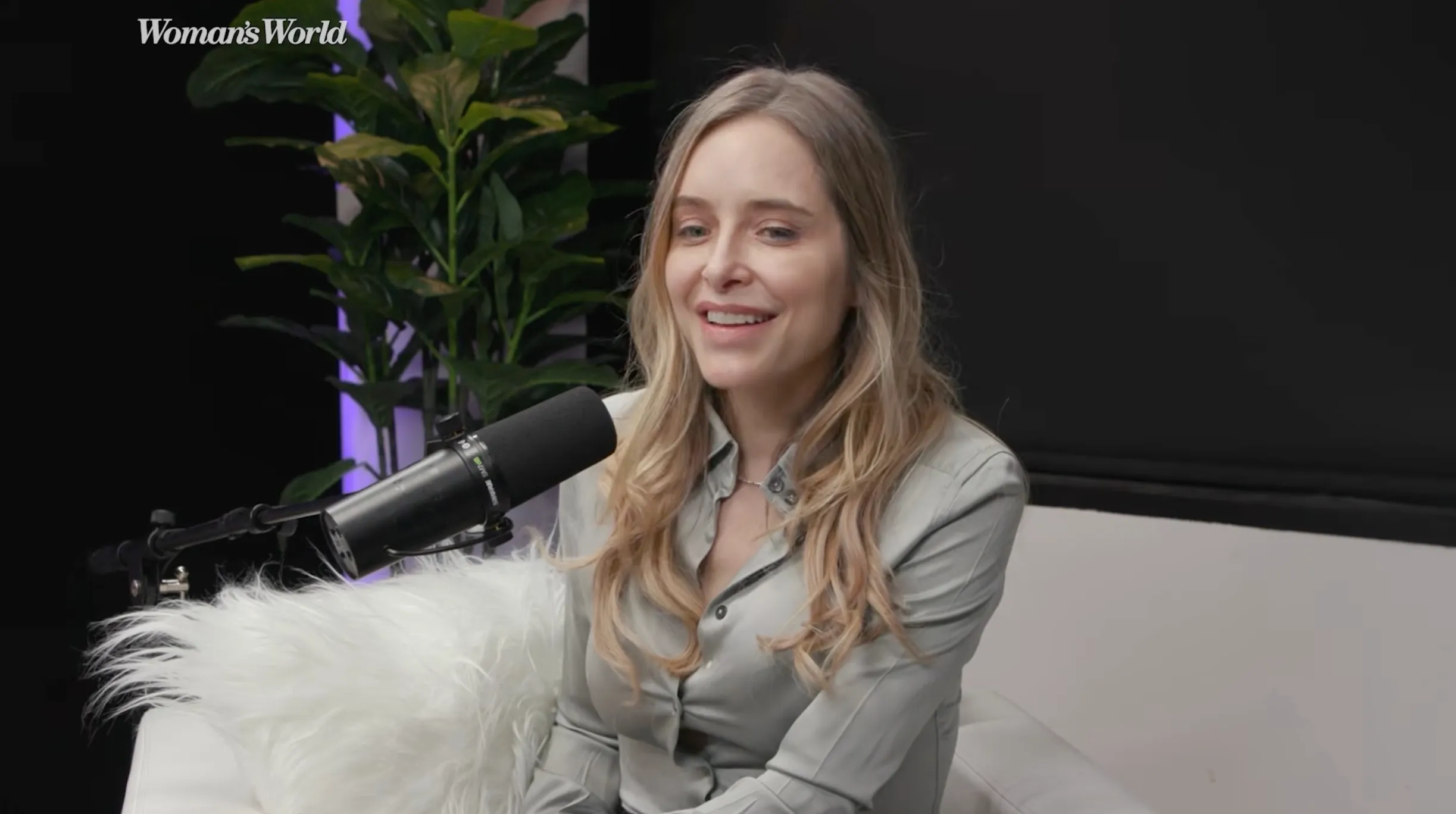 Jenny Mollen sitting on a white sofa during an interview.
