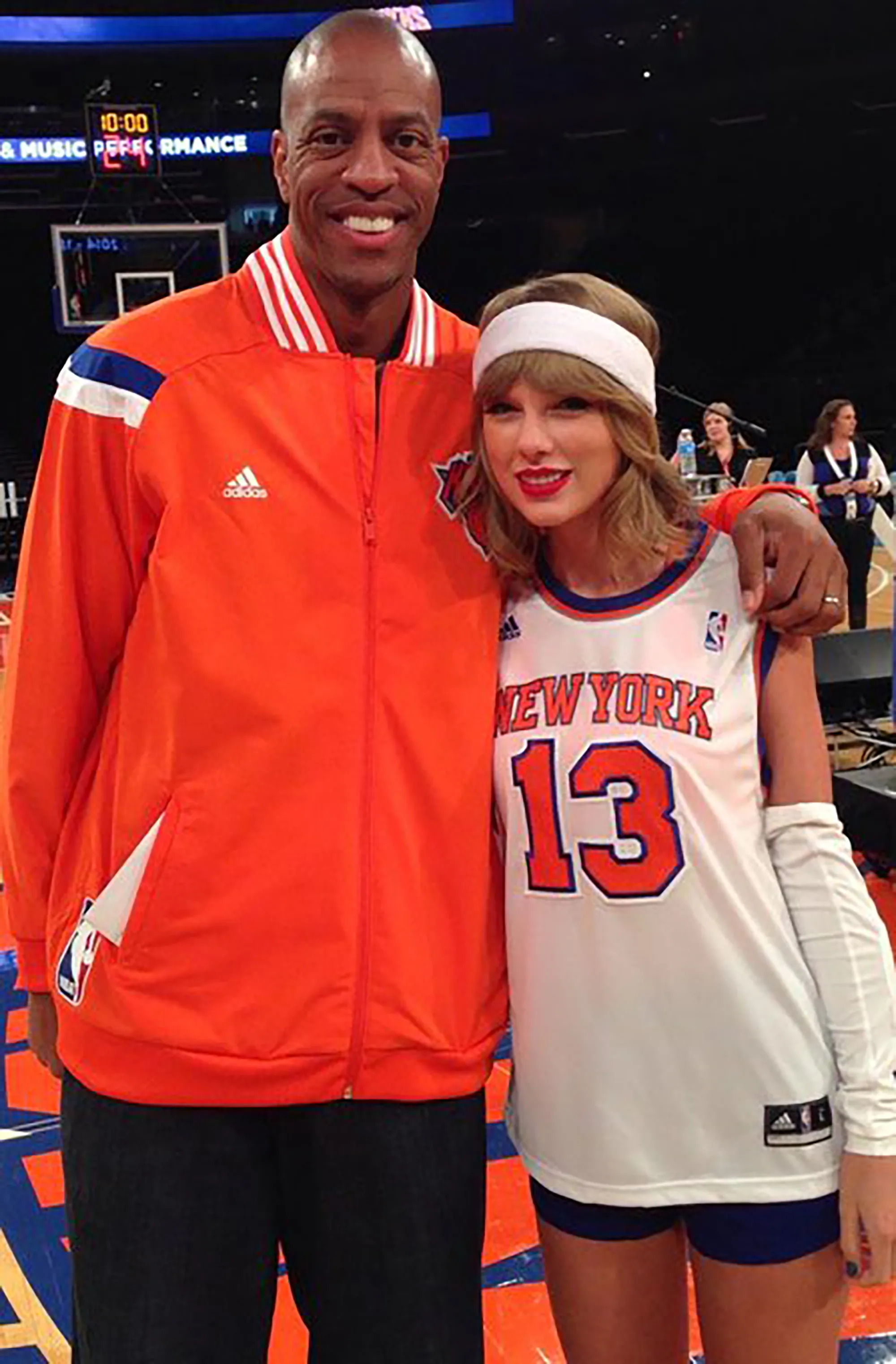 Jerome Williams and Taylor Swift pose together on a basketball court.